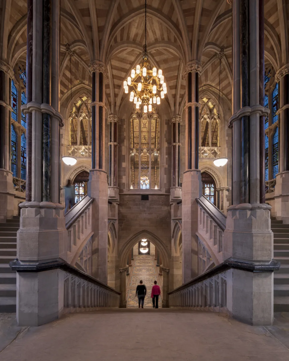 Large chandelier hanging above stone staircase