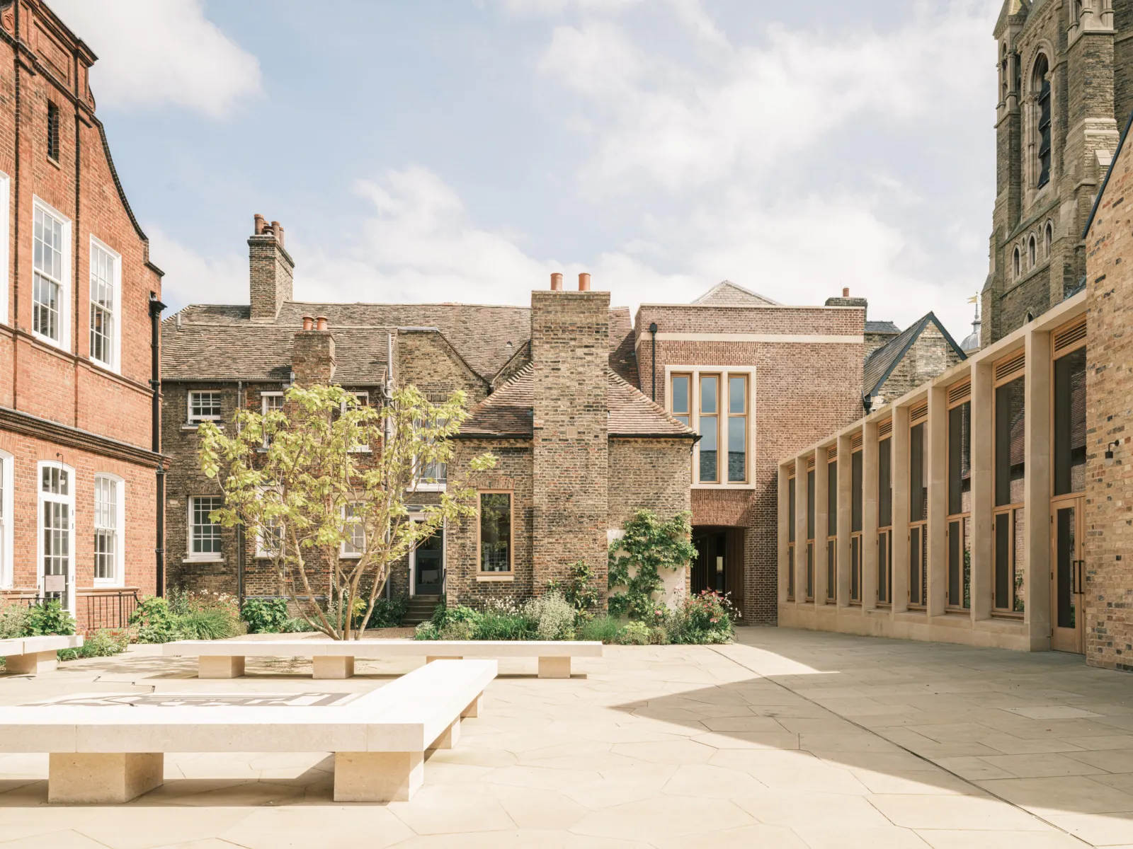 historic stone building with modern extension and courtyard seating.
