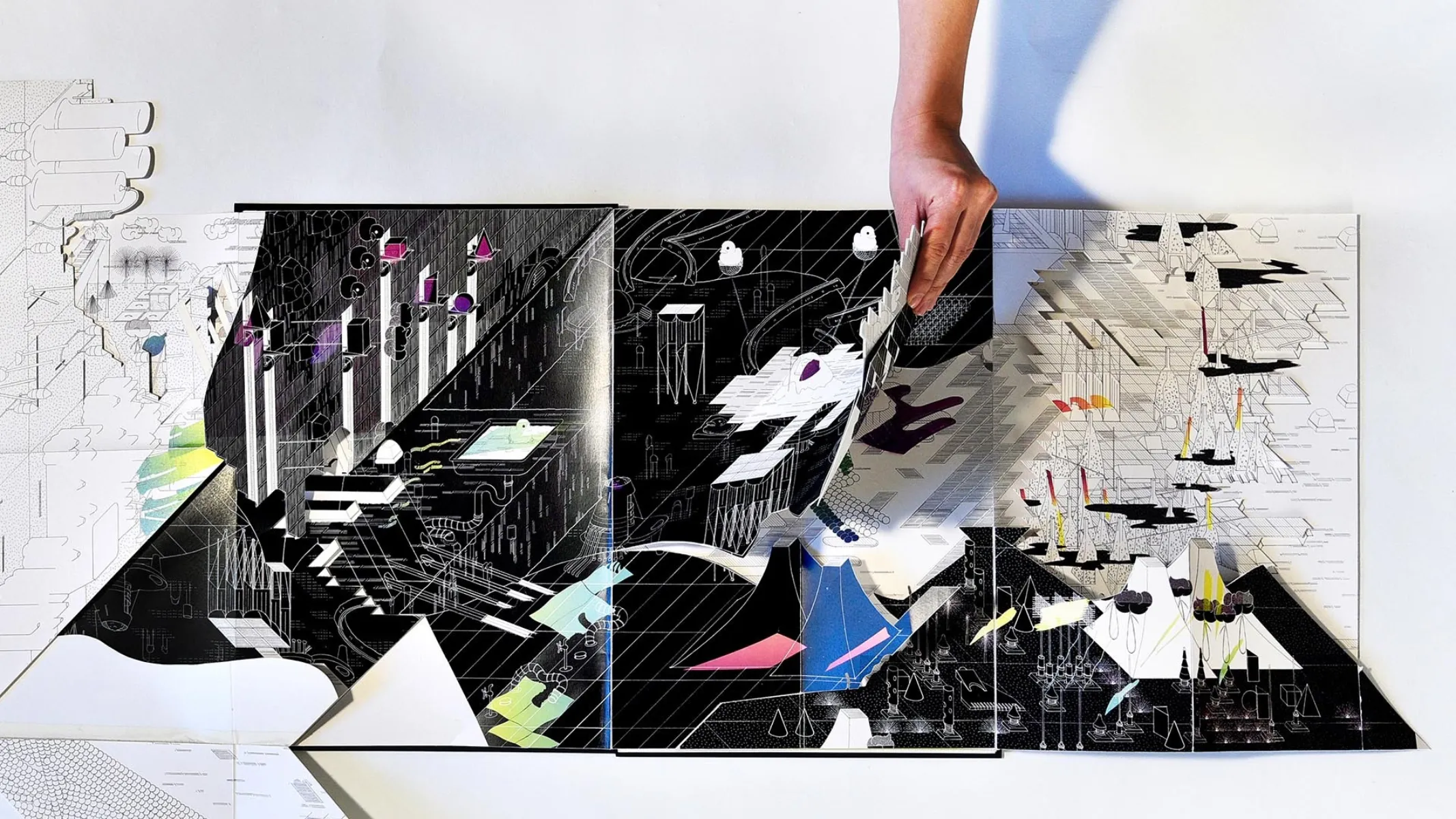 Person's hand above geometric, abstract line drawing, mainly white lines on black background.