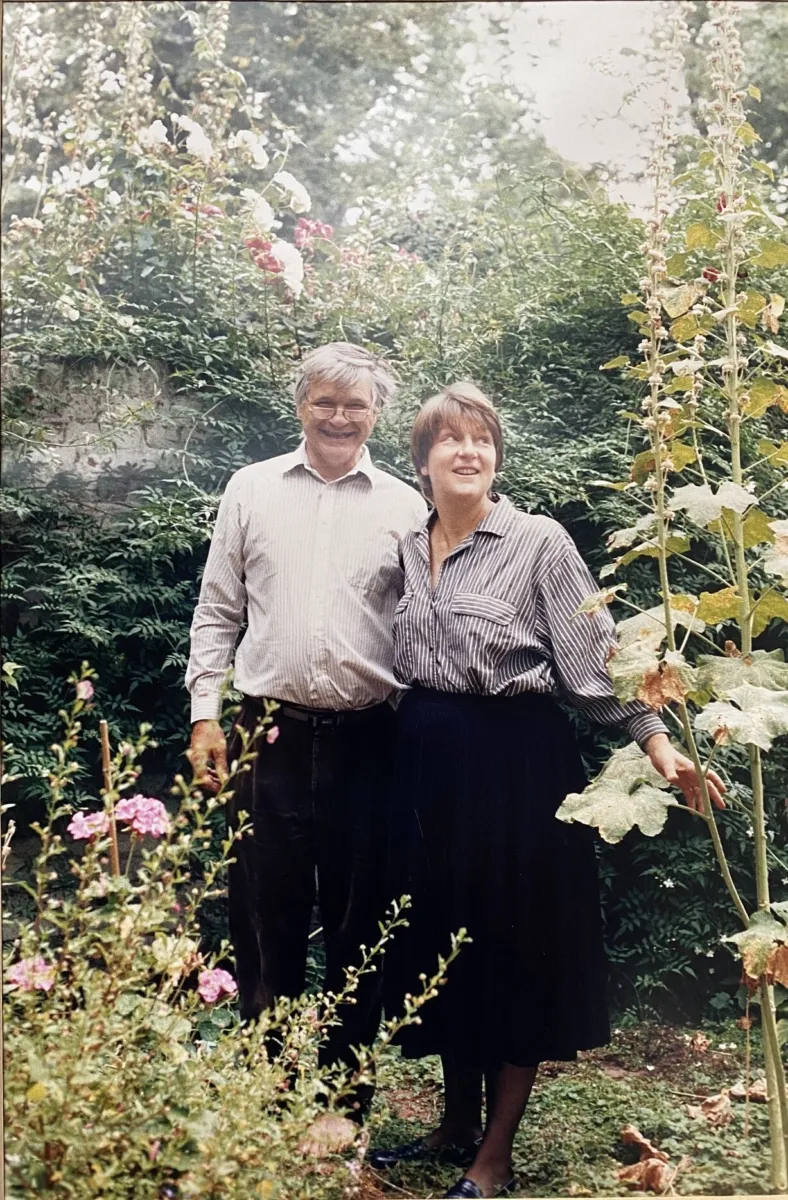 1980s colour photograph of Max and his wife Taddy in their garden, standing together and smiling at the camera.