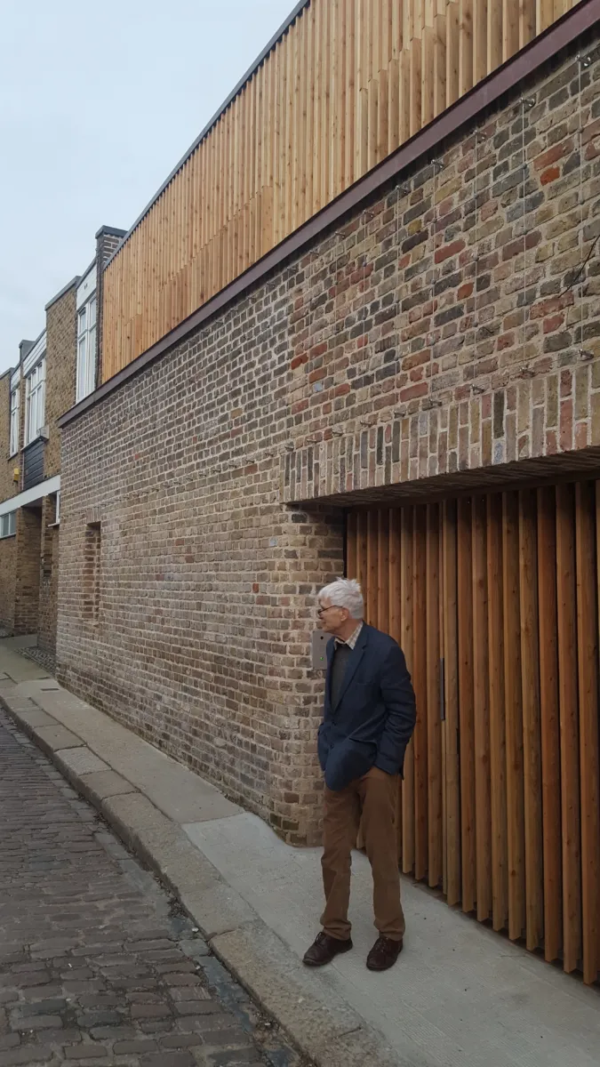 Maax stands in front of his new home