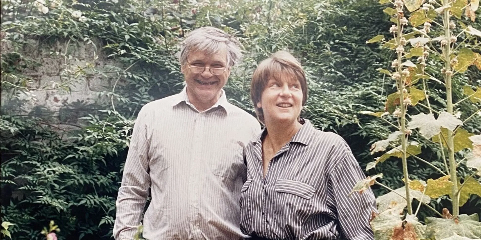1980s colour photograph of Max and his wife Taddy in their garden, standing together and smiling at the camera.