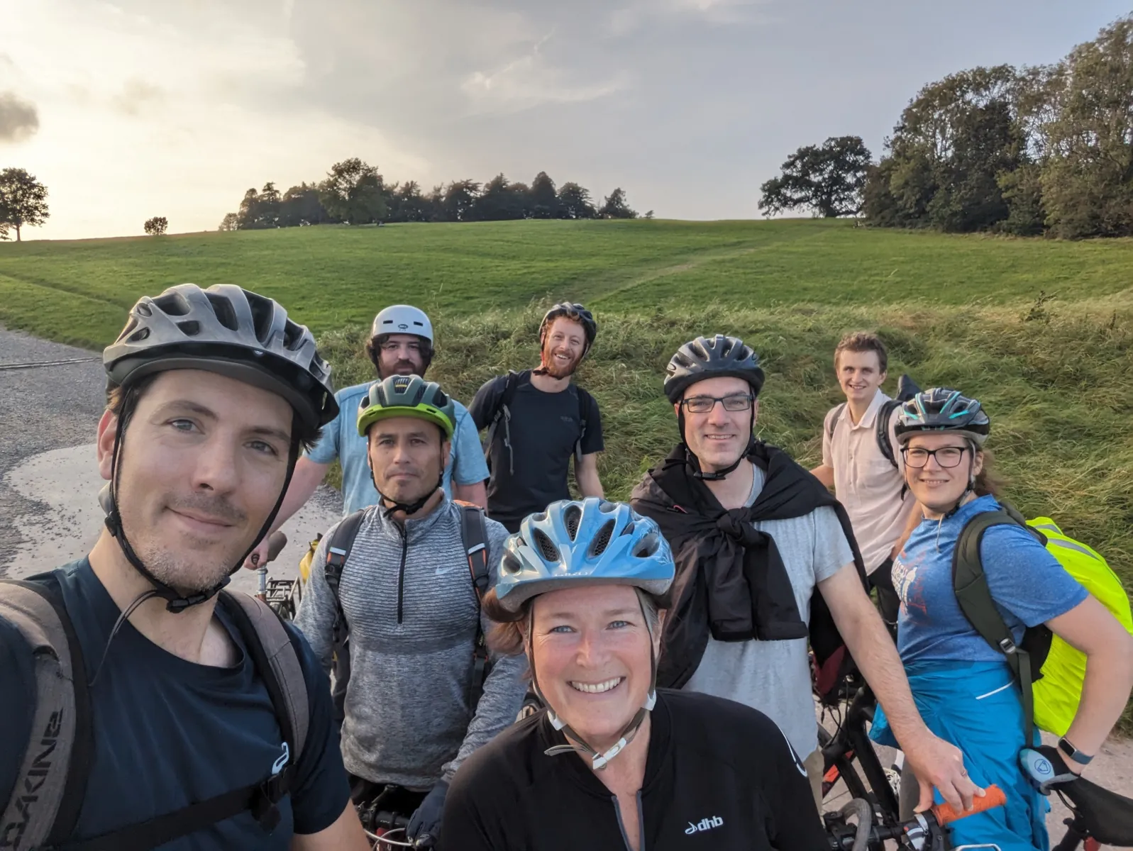 Eight people wearing sports clothes and helmets in a park