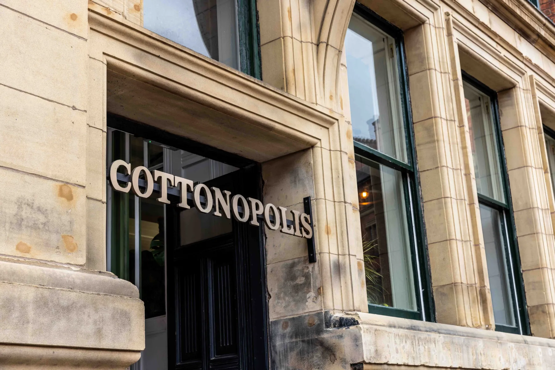Photo showing the stone surround and Cottonopolis sign at the Manchester office entrance.