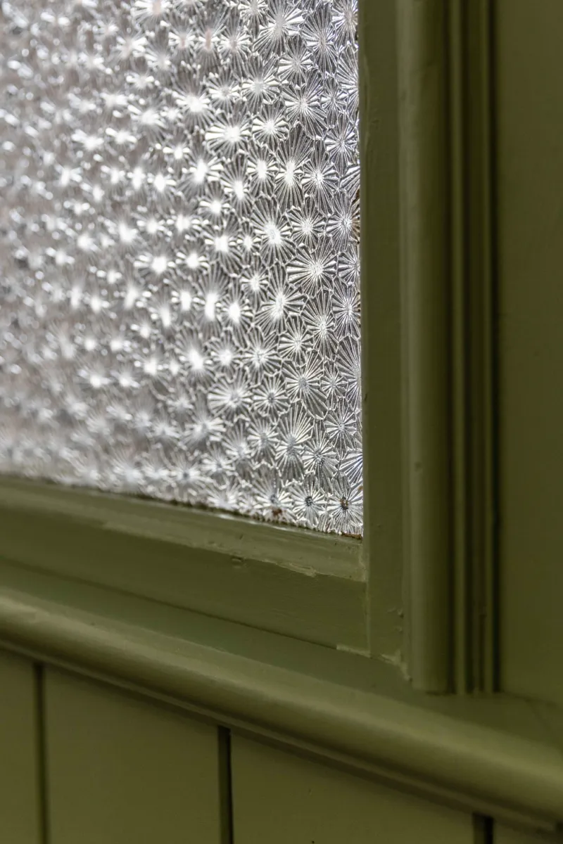 Close up image of frosted internal glazing and green painted timber frame.