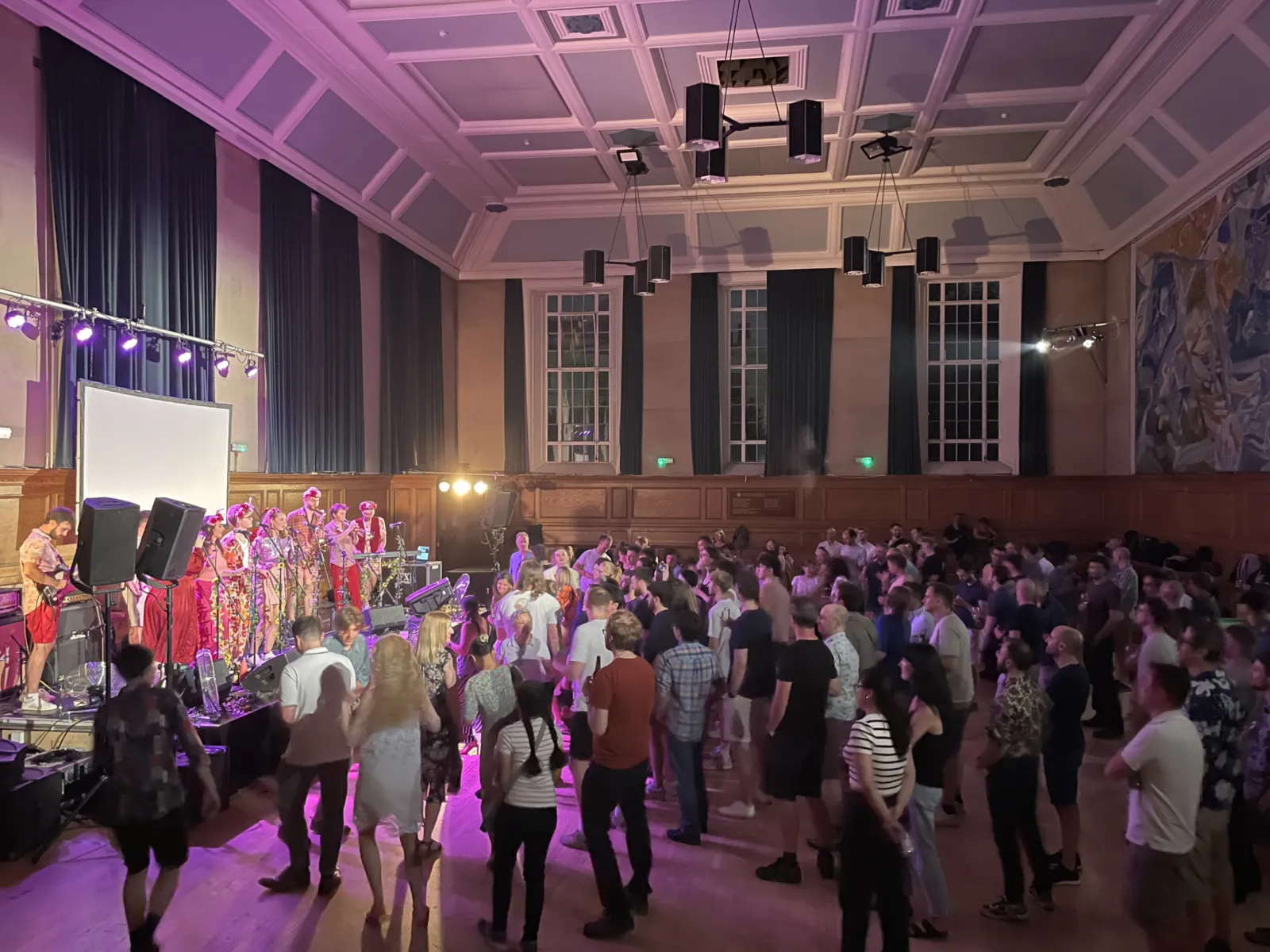 A band performing in front of the audience in an indoor venue