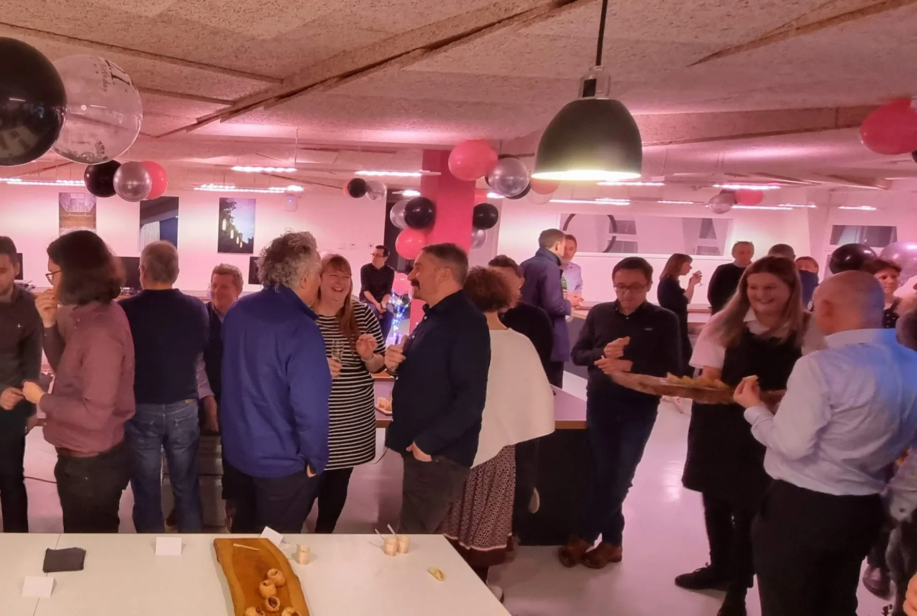 Lots of people chatting and smiling in Max Fordham Cambridge office