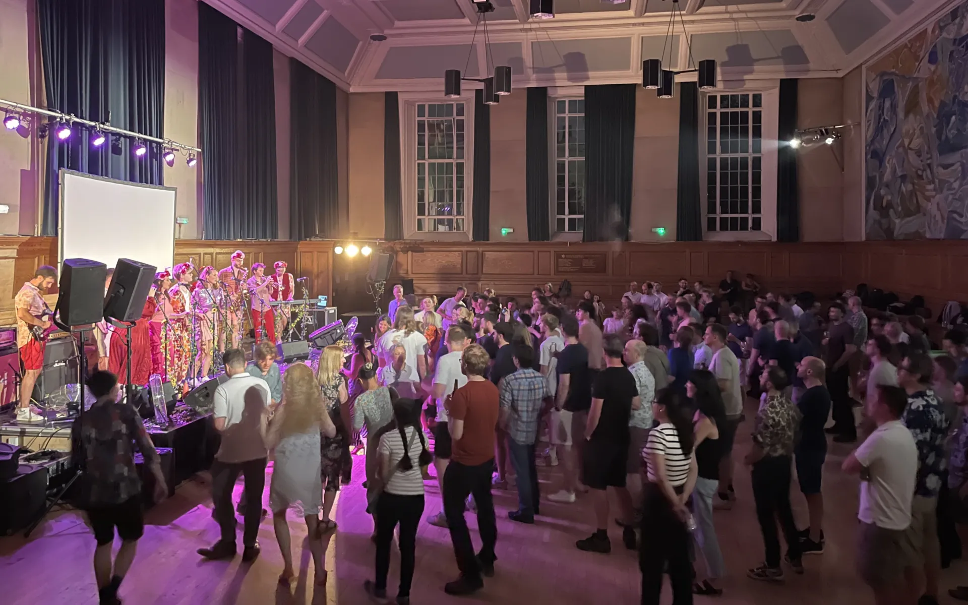 A band performing in front of the audience in an indoor venue