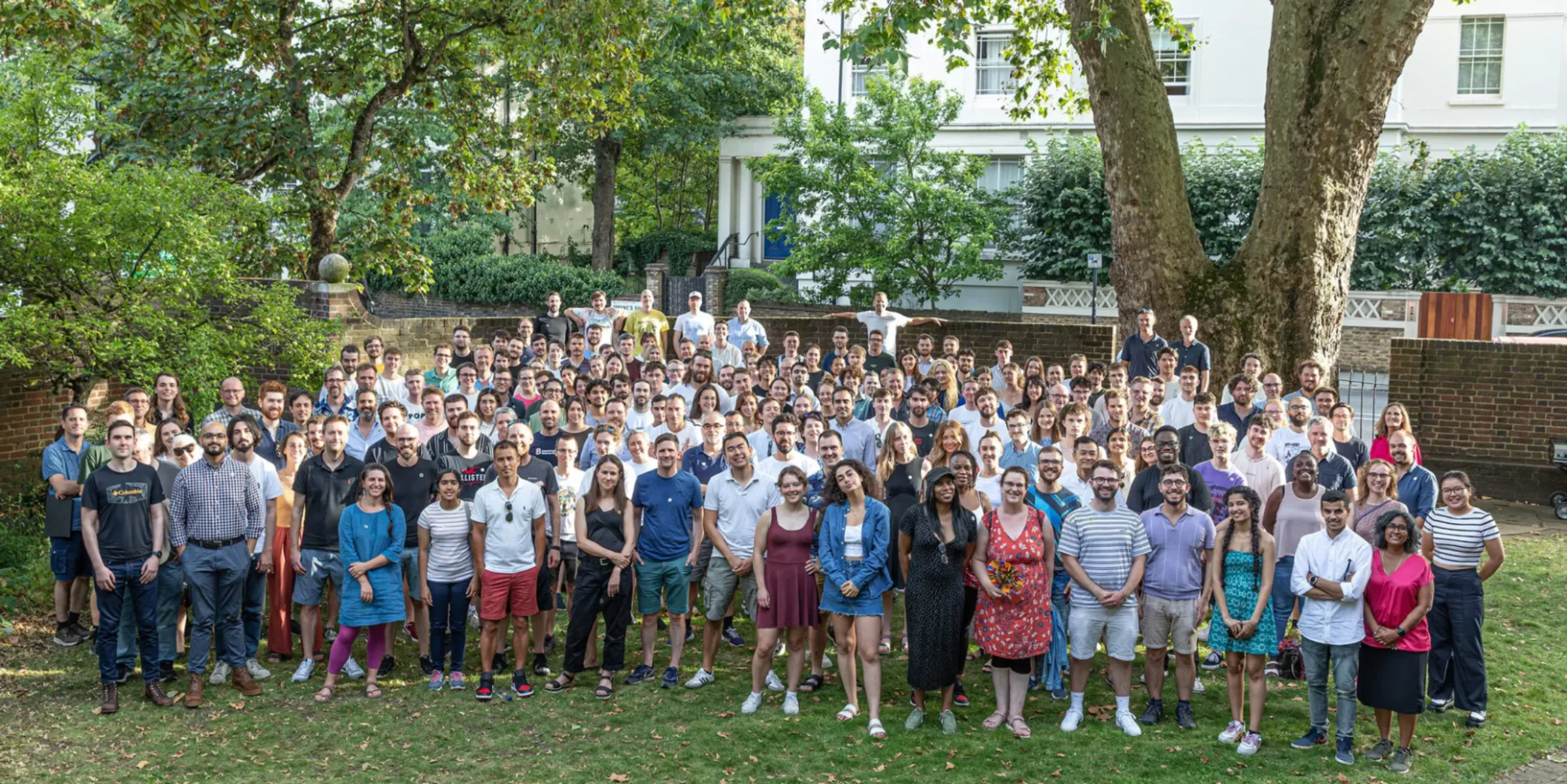large group of people standing outside in a garden