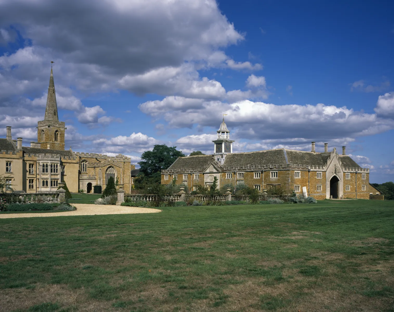 The opera house from the outside, a cotswold stone building surrounded by fields