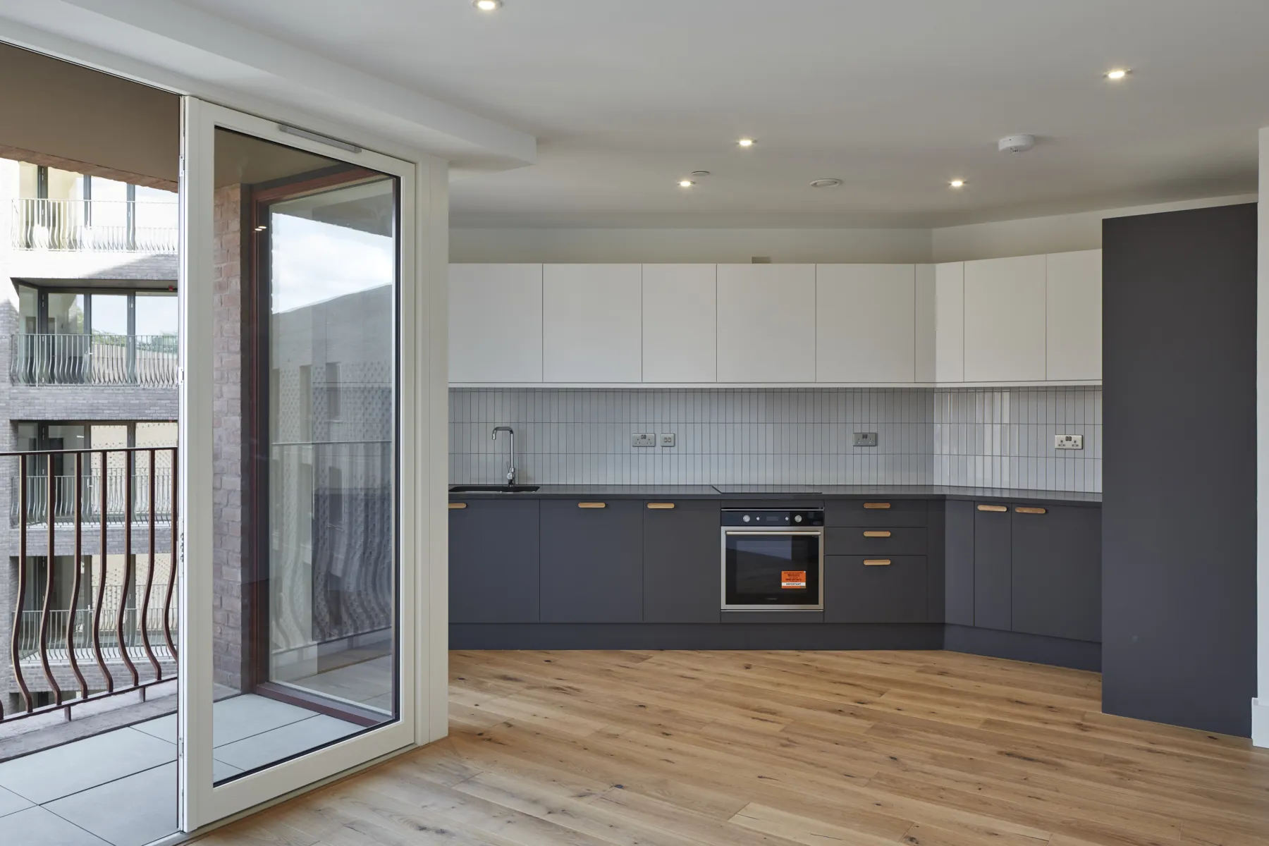 Open-plan apartment kitchen with balcony access.