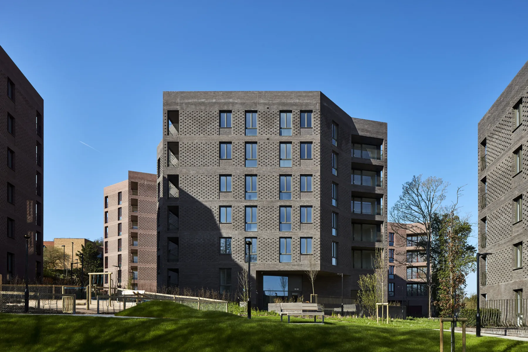 Modern brick residential blocks surrounding landscaped communal green space