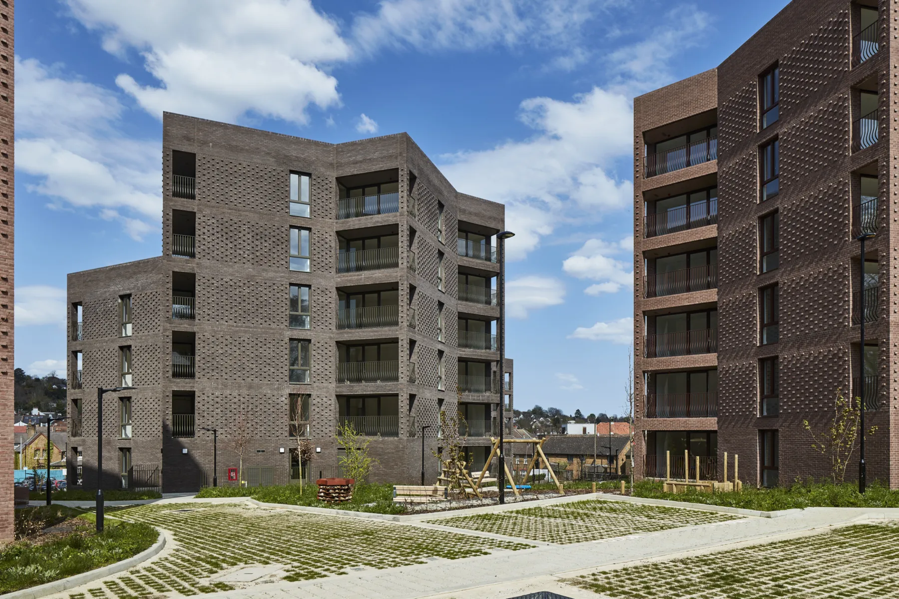 Contemporary apartment buildings with balconies around a shared courtyard.