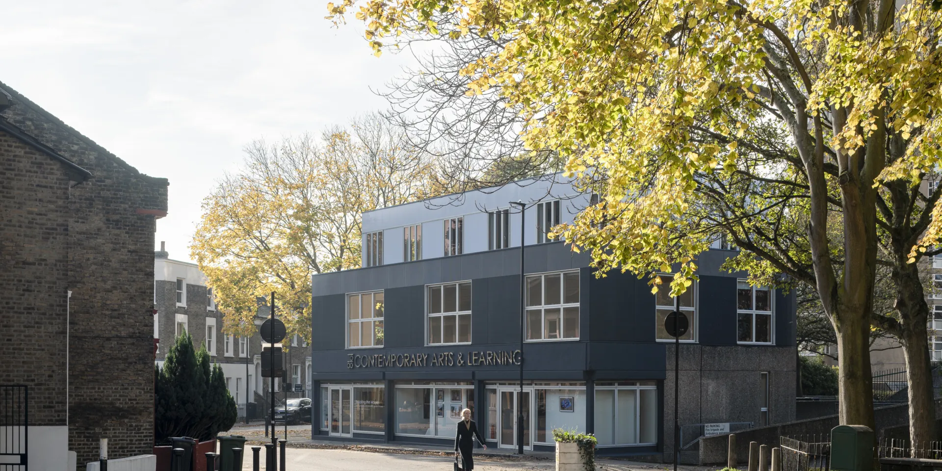 The exterior of a three storey building on an autumnal street