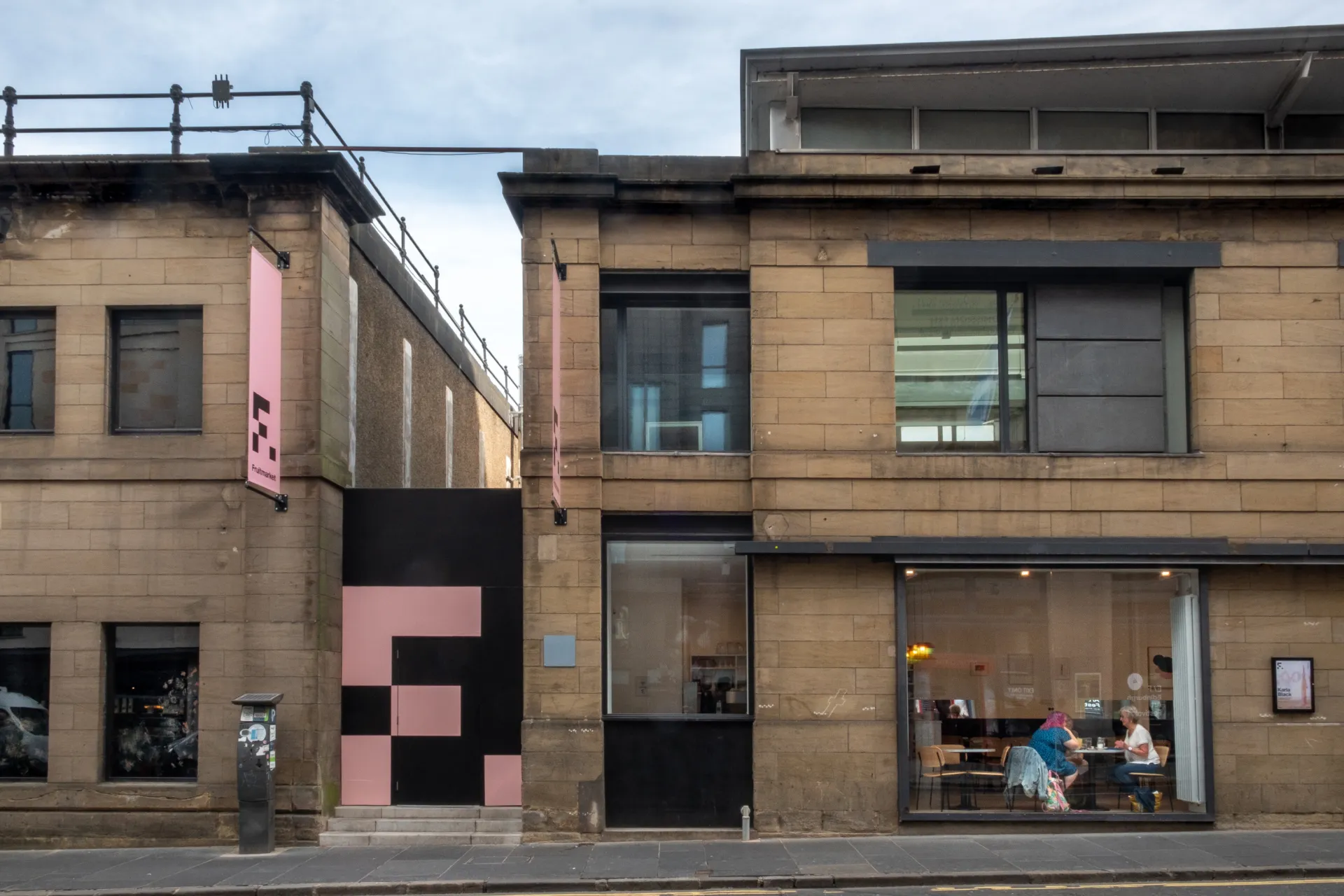 The exterior of a two storey stone-fronted building