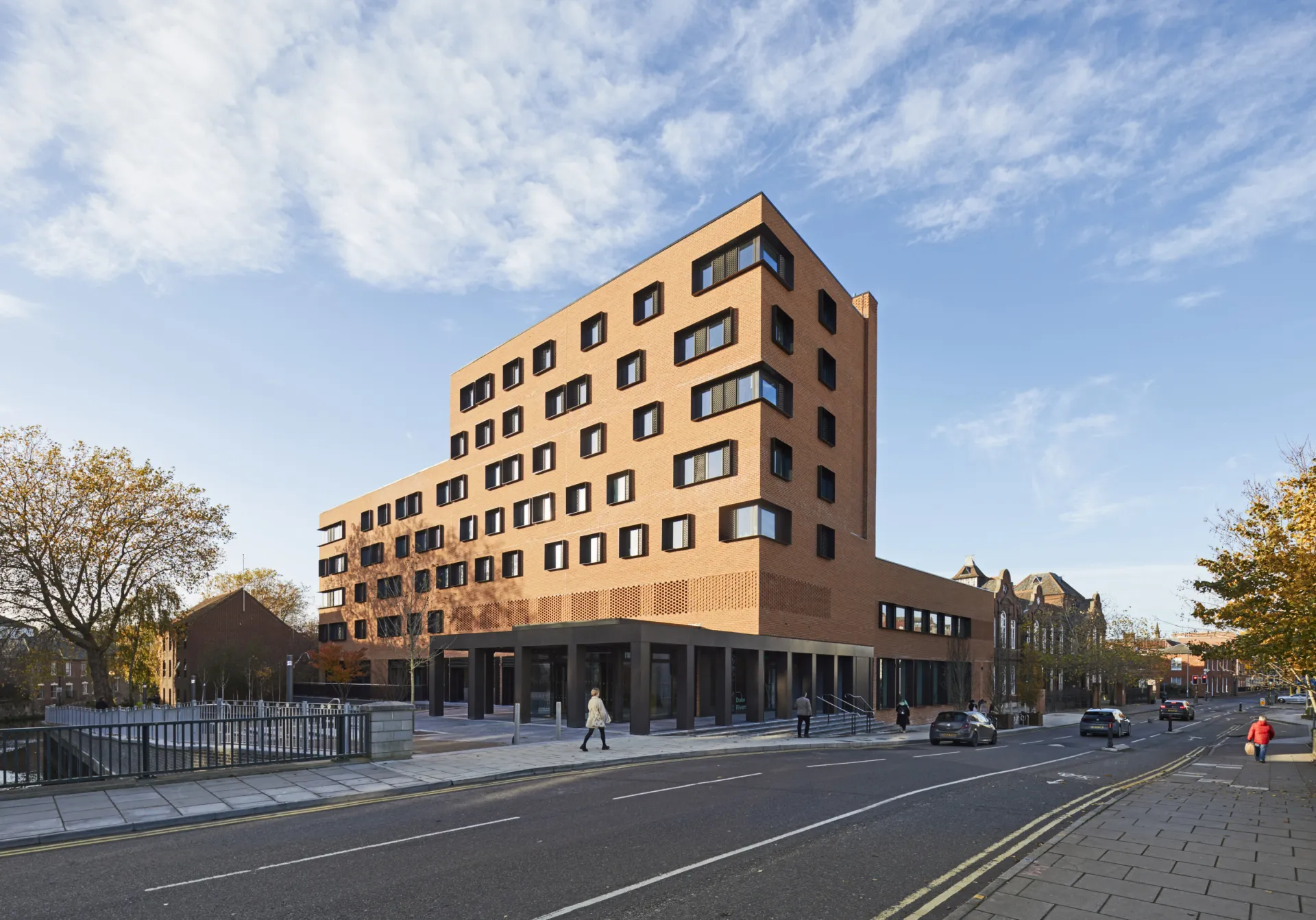 The exterior of Duke Street, a block of red-brick flats, on a sunny autumn day.