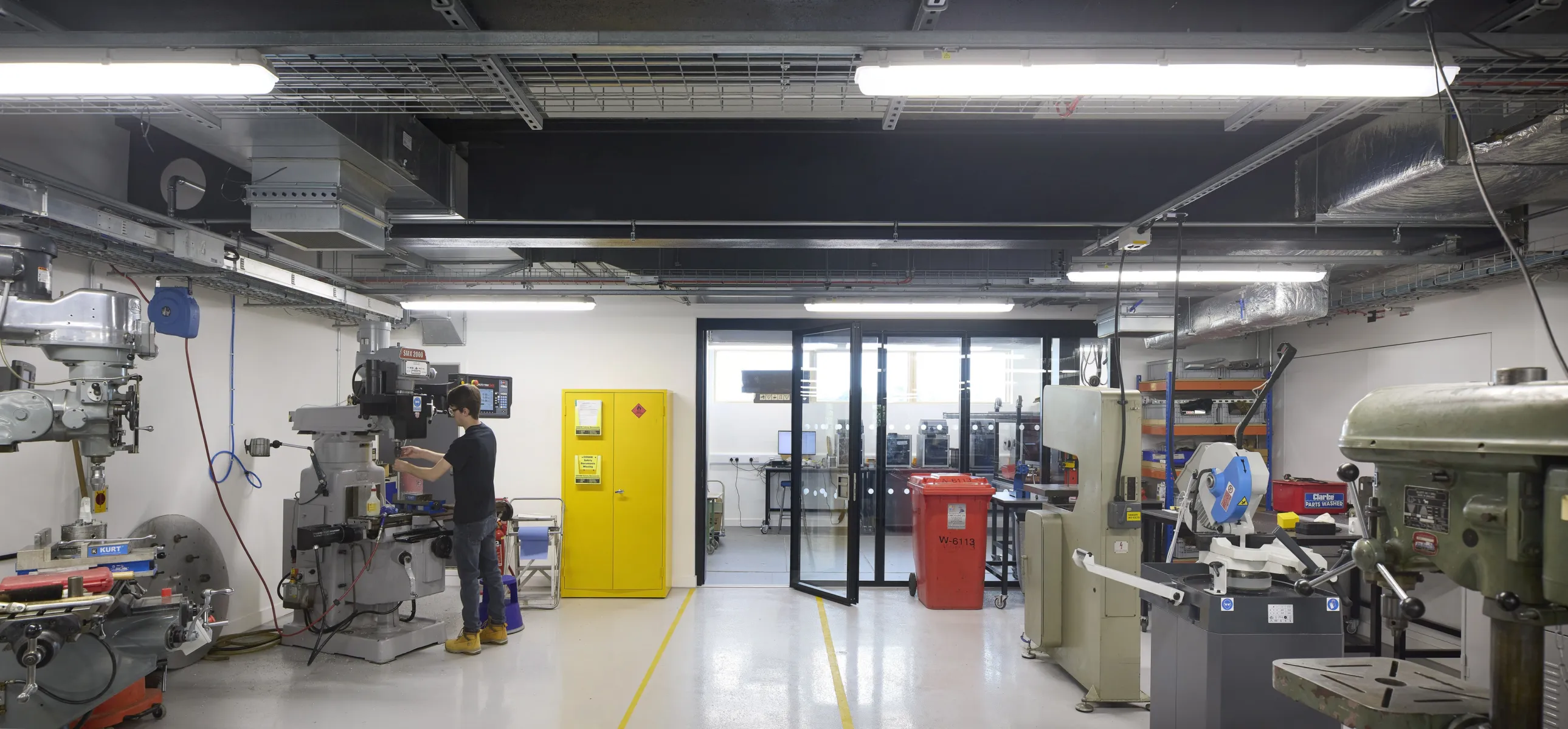 Engineering workshop with machining equipment and a researcher at work.