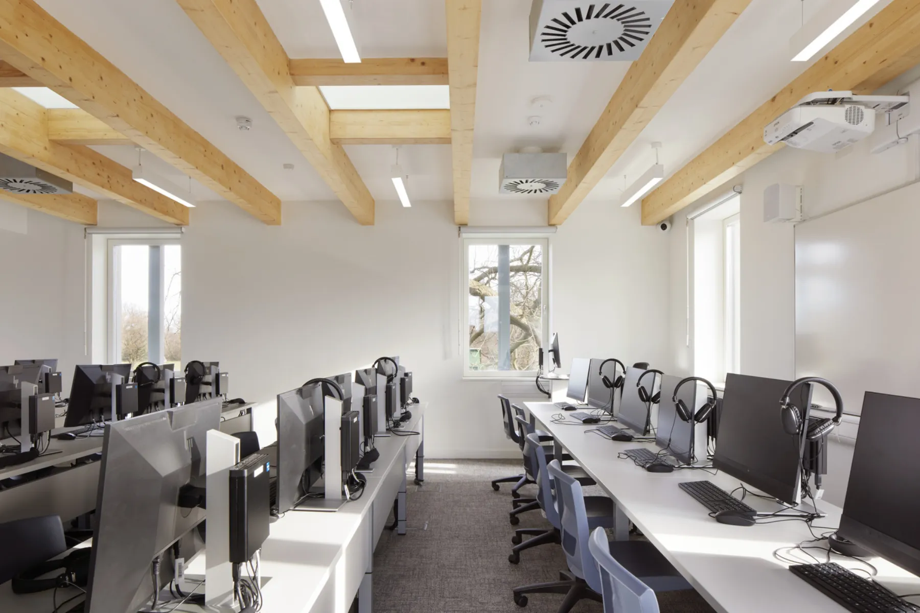 classroom with computer screens and mechanical vents
