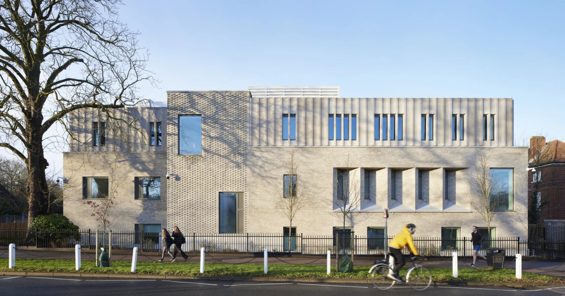 Light grey building with cyclist and walkers