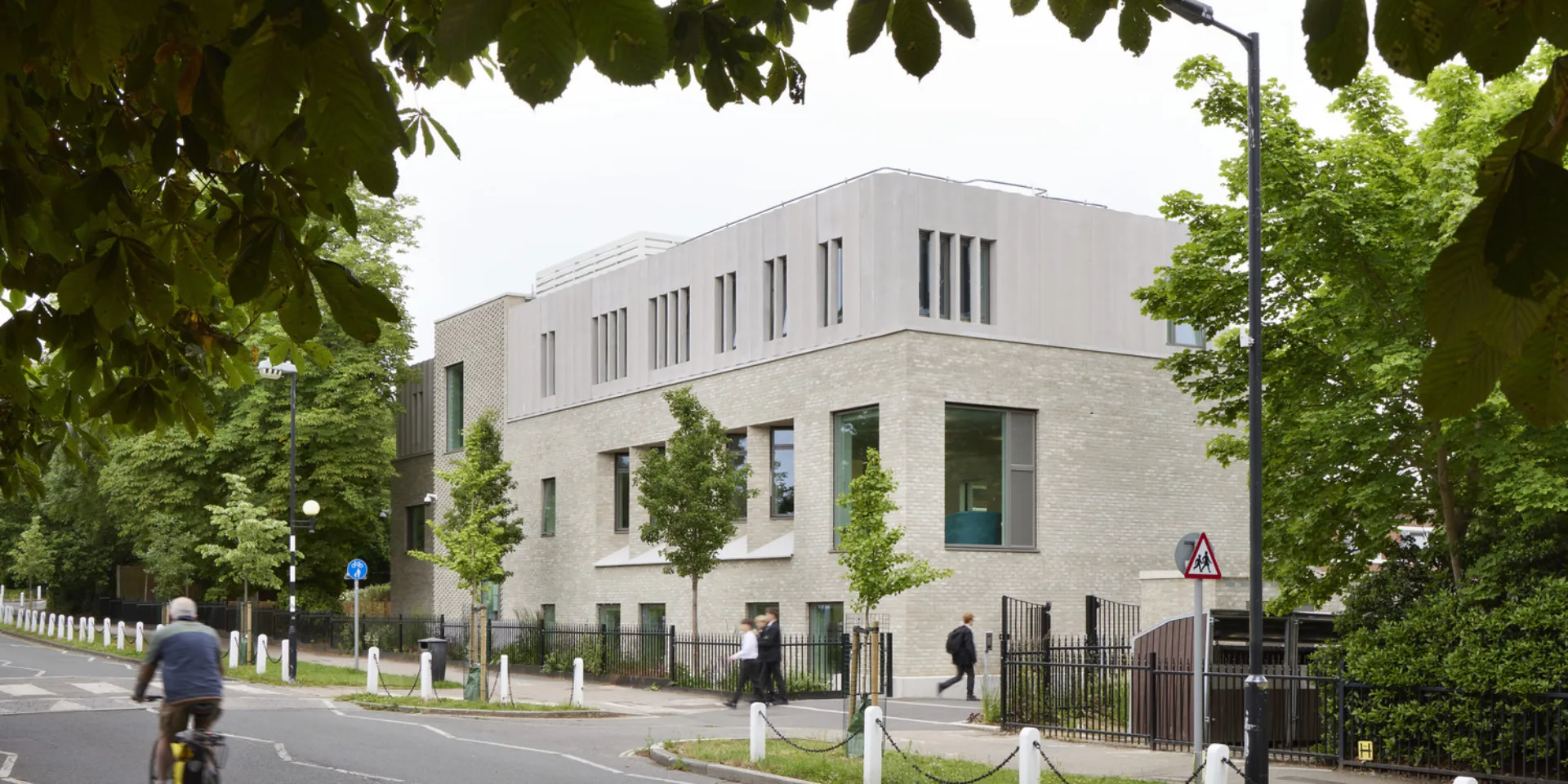 Light grey building on a leafy road