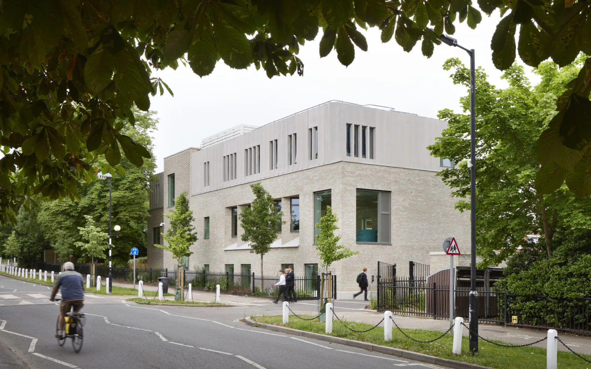 Light grey building on a leafy road