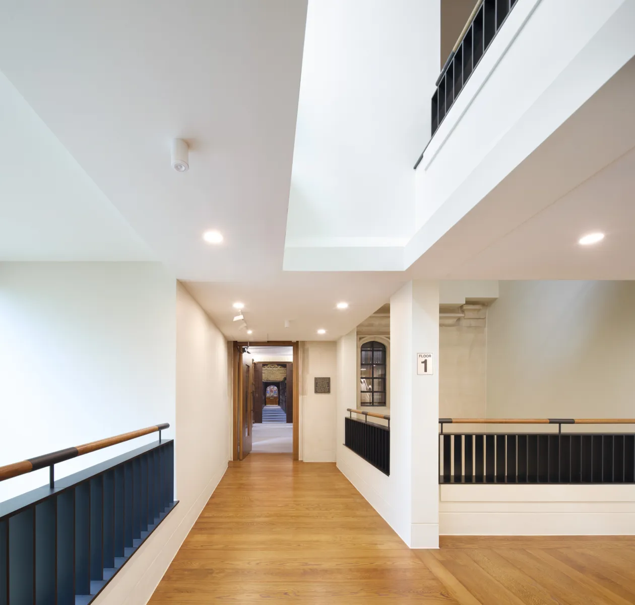 Modern floor with balustrades and doorway leading into a historic library
