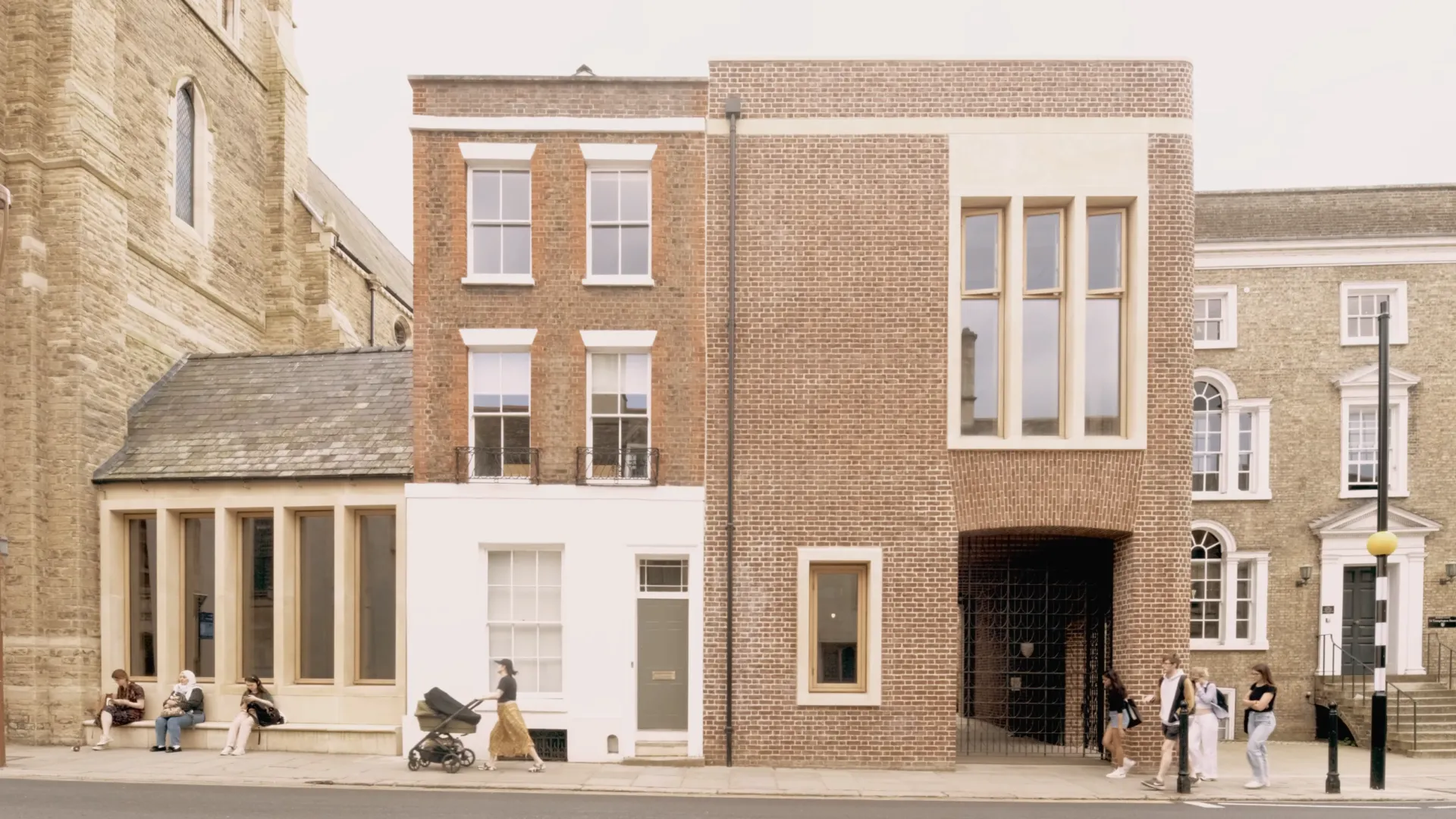 People walking in front of a brick building