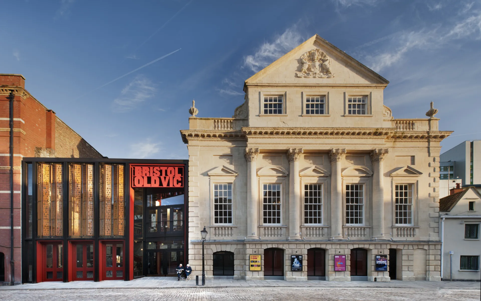 A theatre surrounded by historic buildings and bustling streets