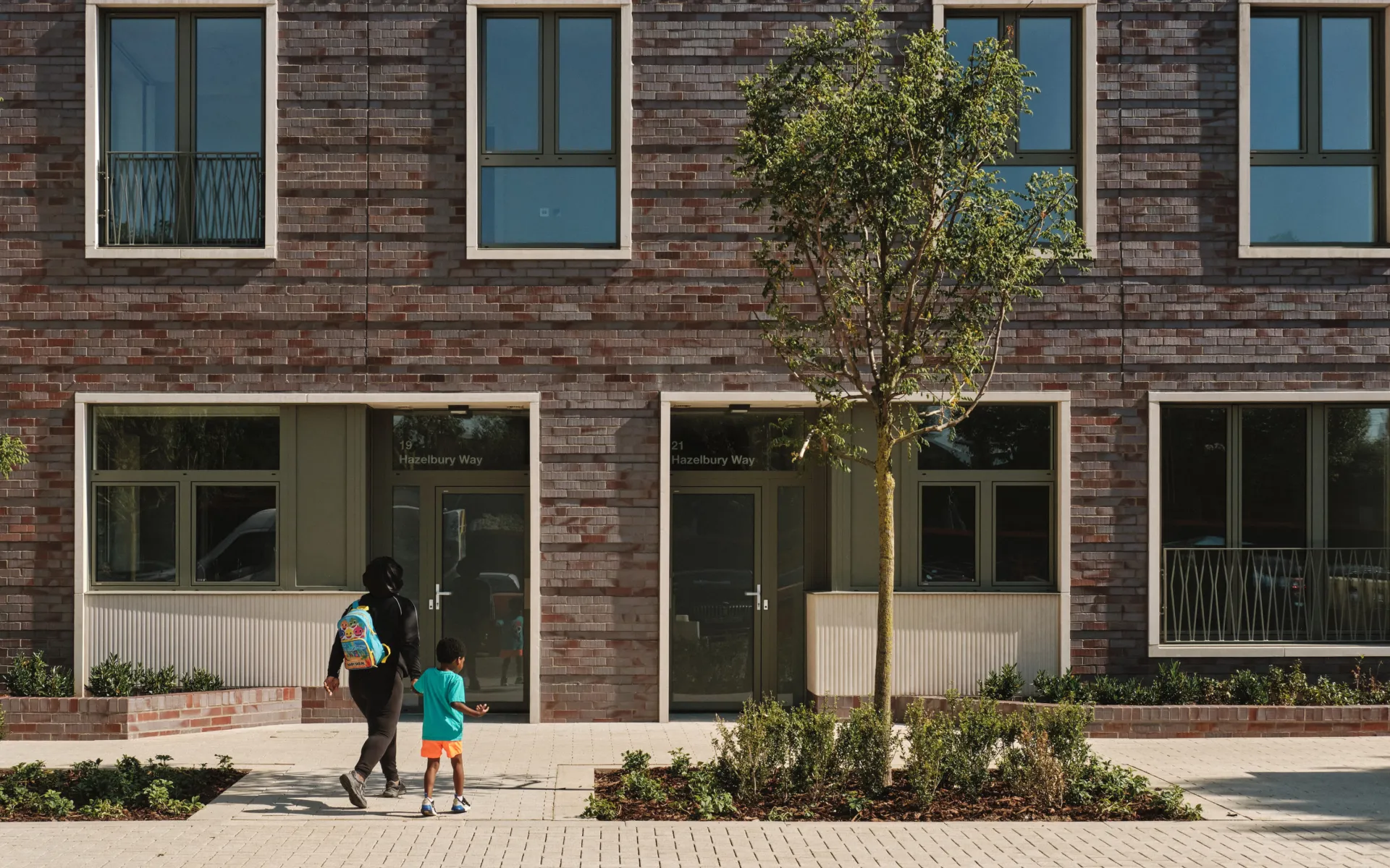 Mum and son walk into building