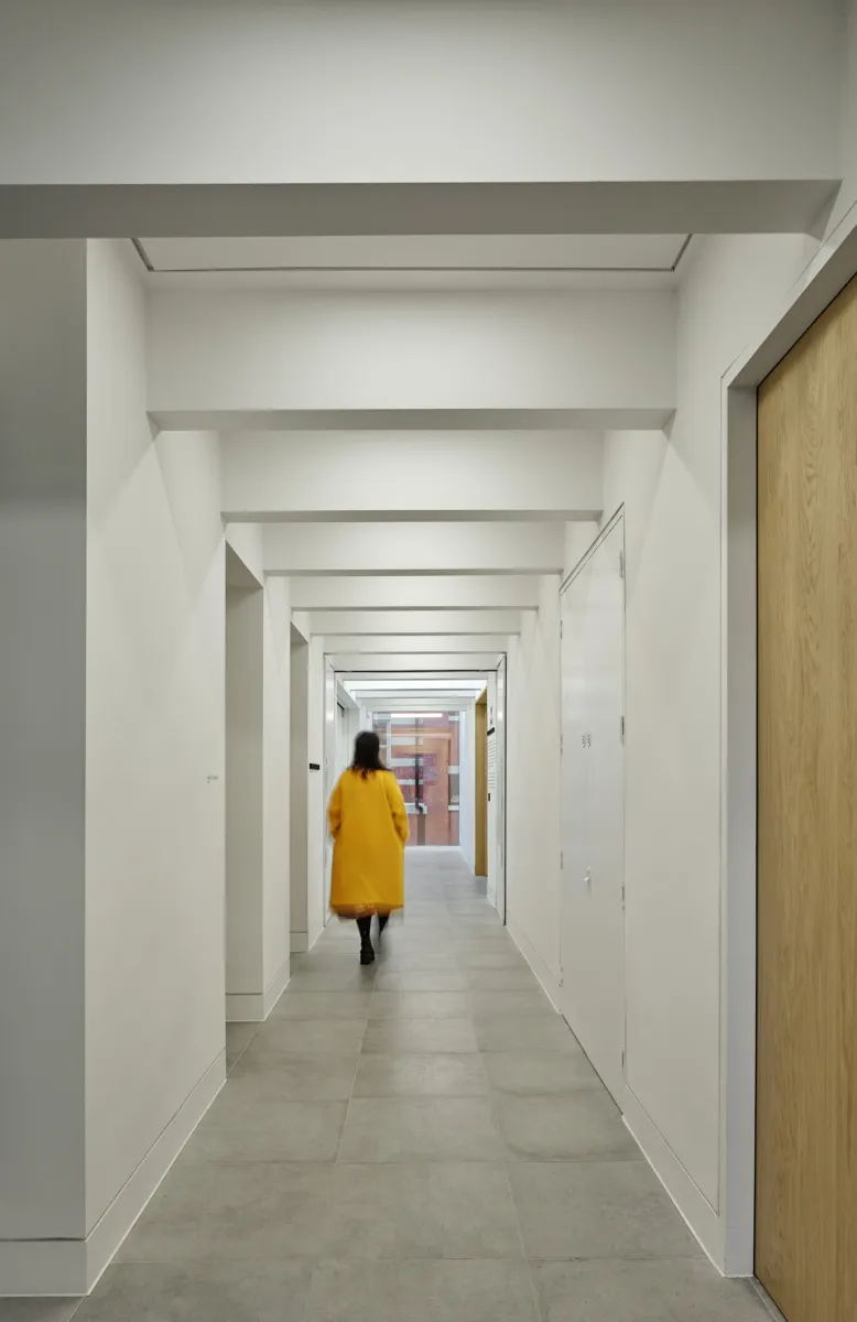 A person in yellow jacket walking down a hallway