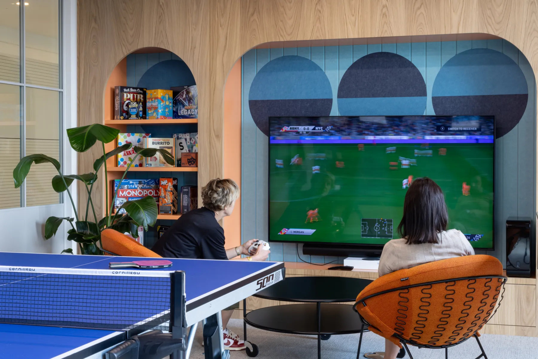 Two individuals playing video game in a room