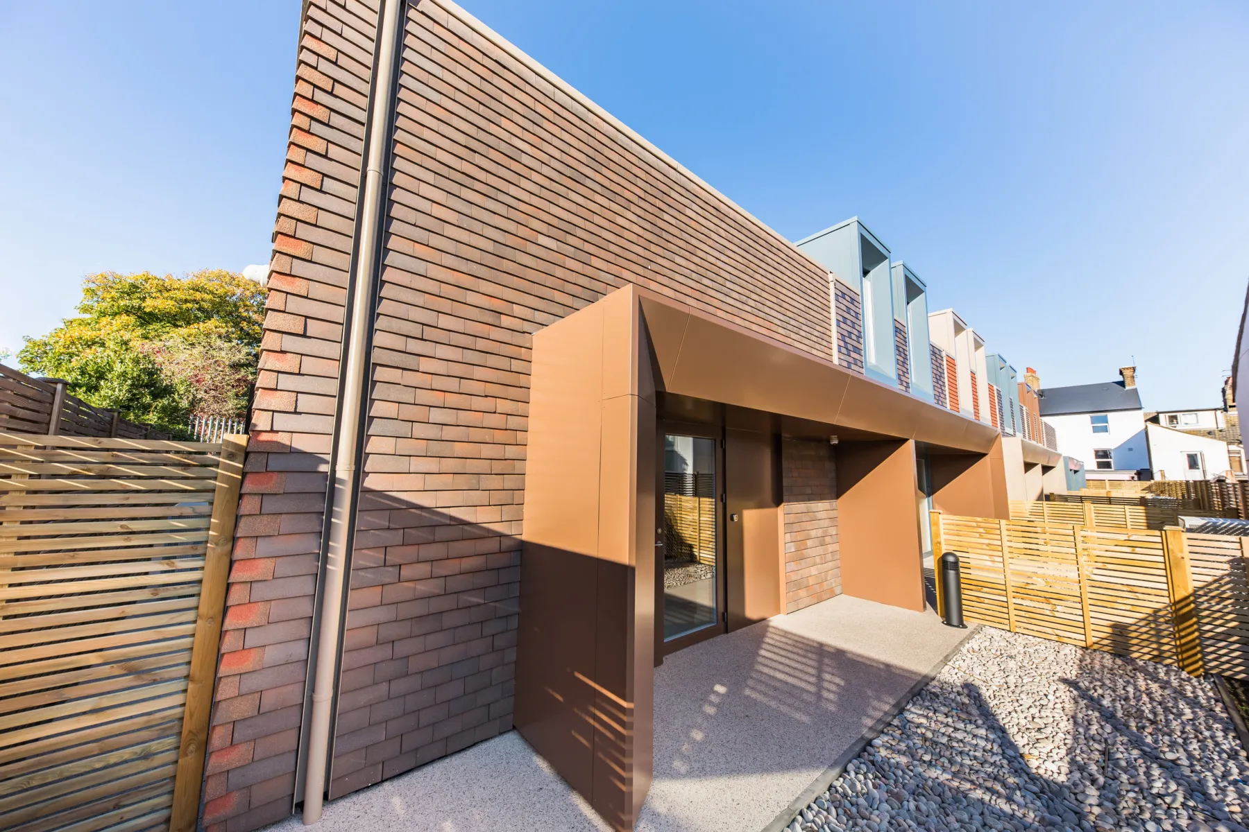 The exterior of a brick building, lit by sunshine