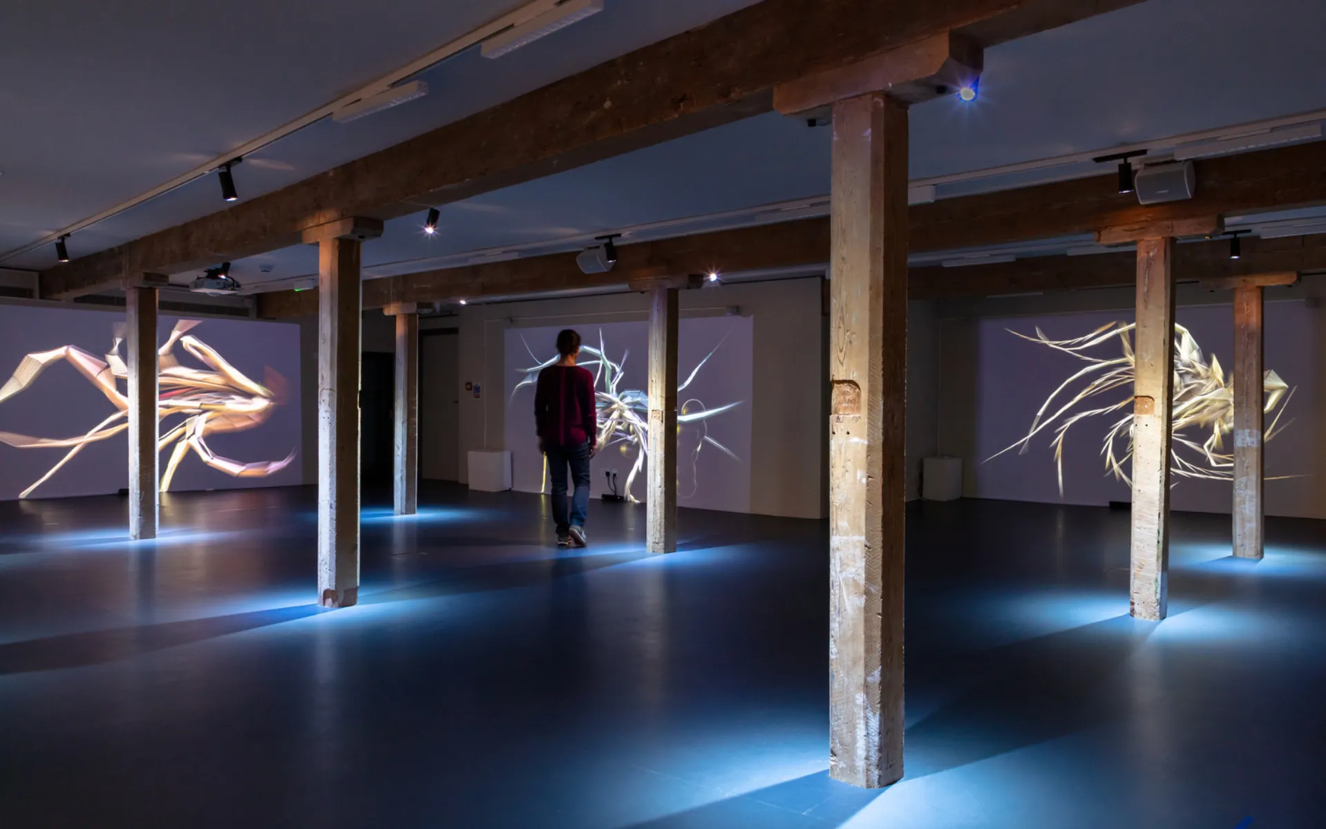 dark room with old wooden pillars and images shown projected onto the wall