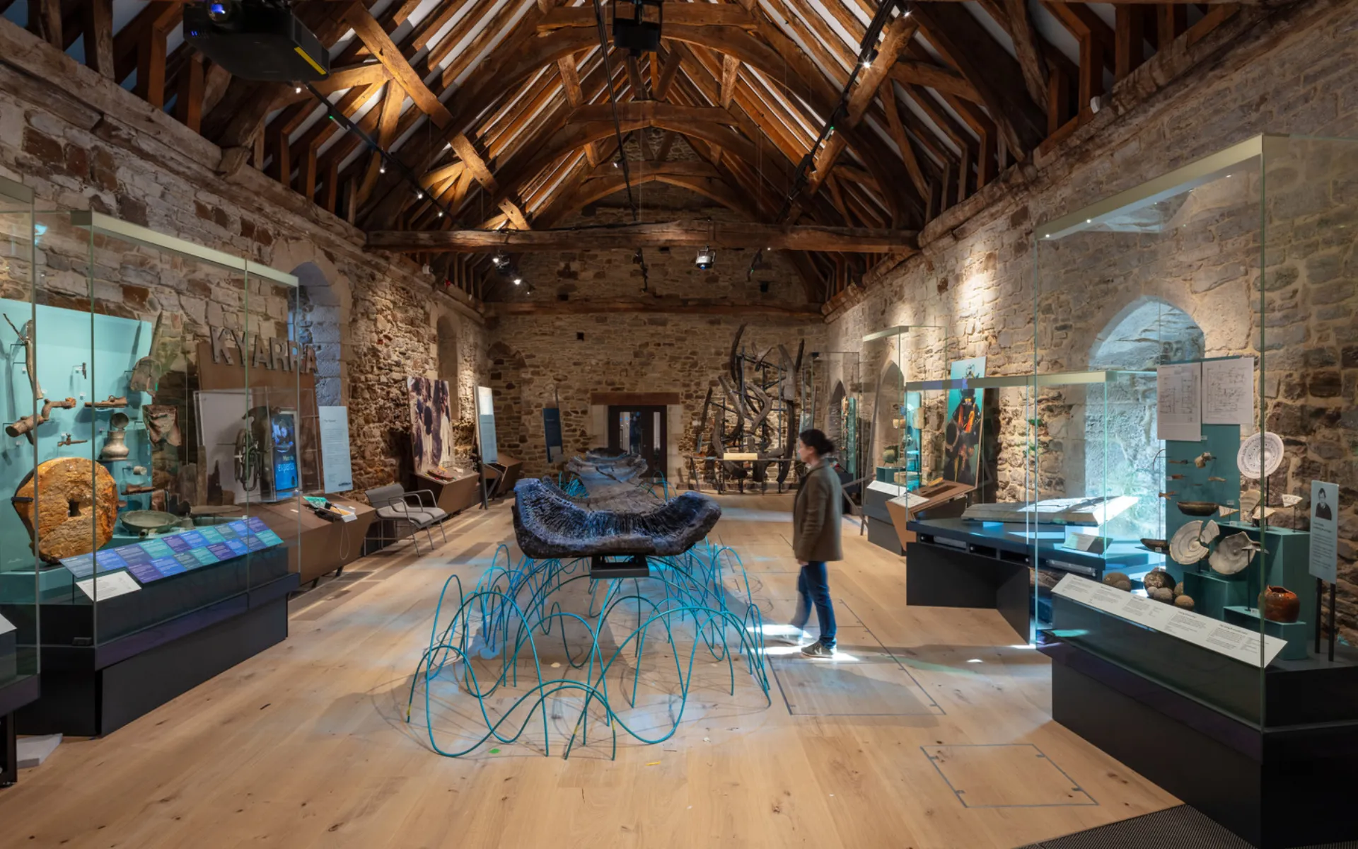 interior or a museum with stone walls in exhibits, including a very old log boat