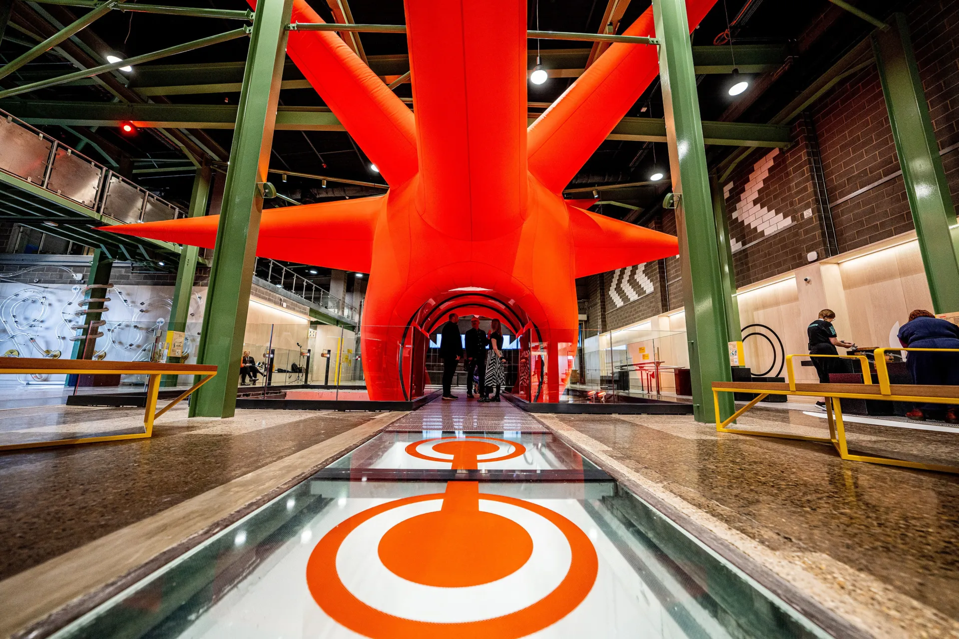 Large orange star shaped art installation in a high ceiling building