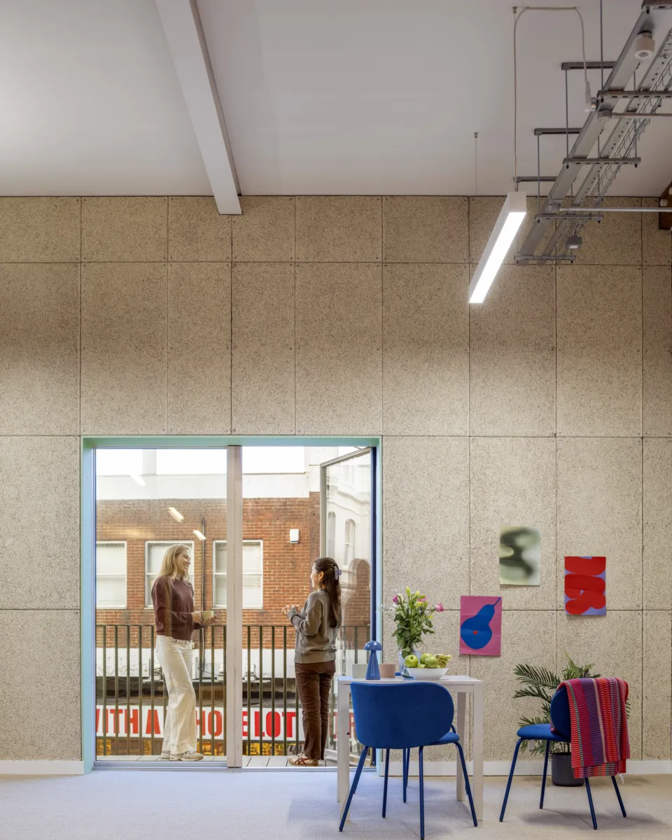 Interior view between office spaces with glazed partitions and circulation areas.