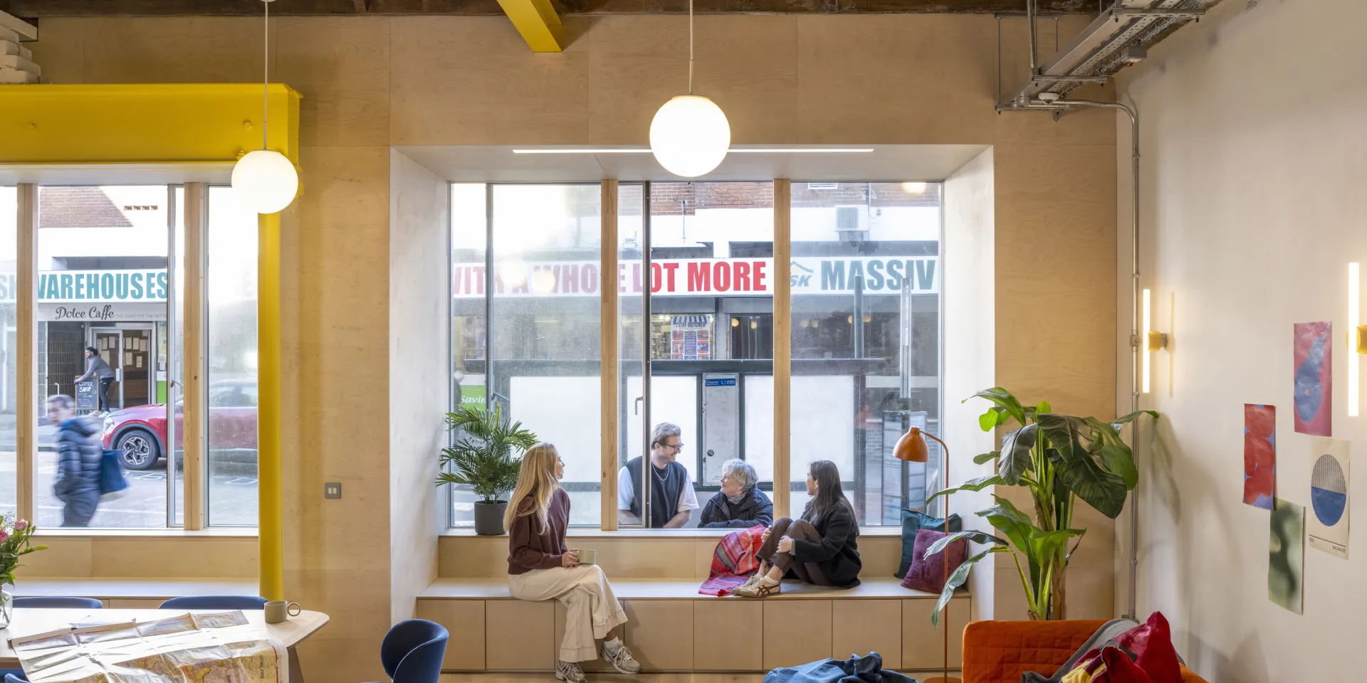 People chatting by a reception desk in a shared workspace.