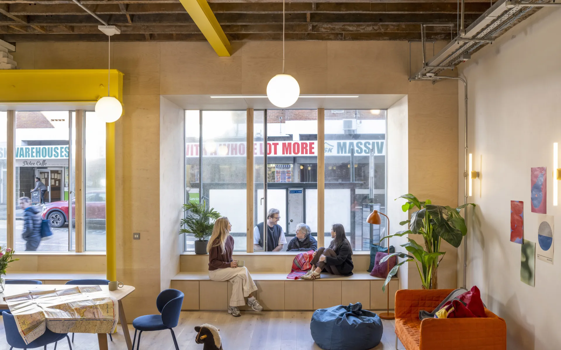 People chatting by a reception desk in a shared workspace.