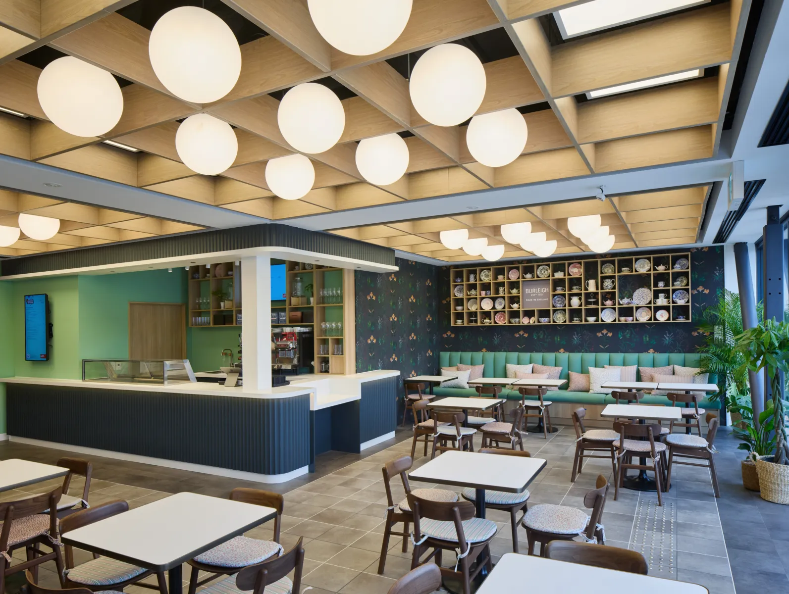 image shows restaurant with tables, chairs and large globe lights