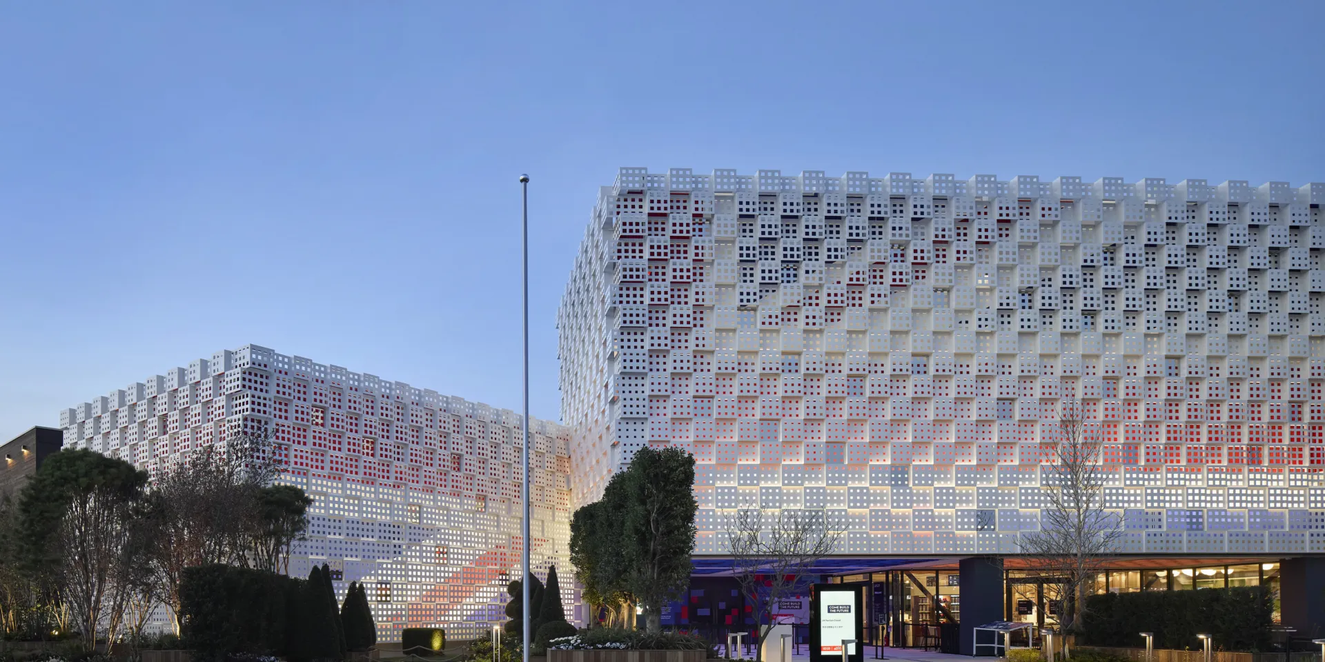 image shows building at dusk. the Union Jack can be seen on the facade of the building