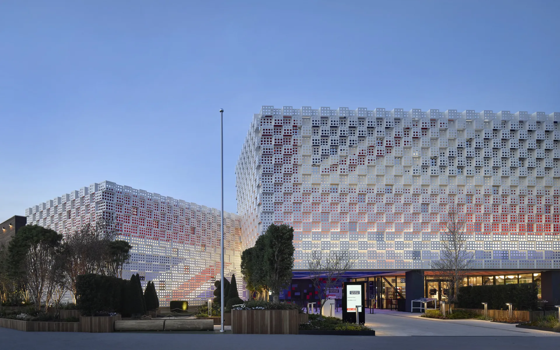 image shows building at dusk. the Union Jack can be seen on the facade of the building