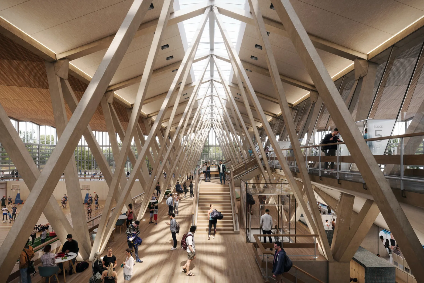 Timber-framed sports hall atrium with central staircase, skylights and people gathering across multiple levels.