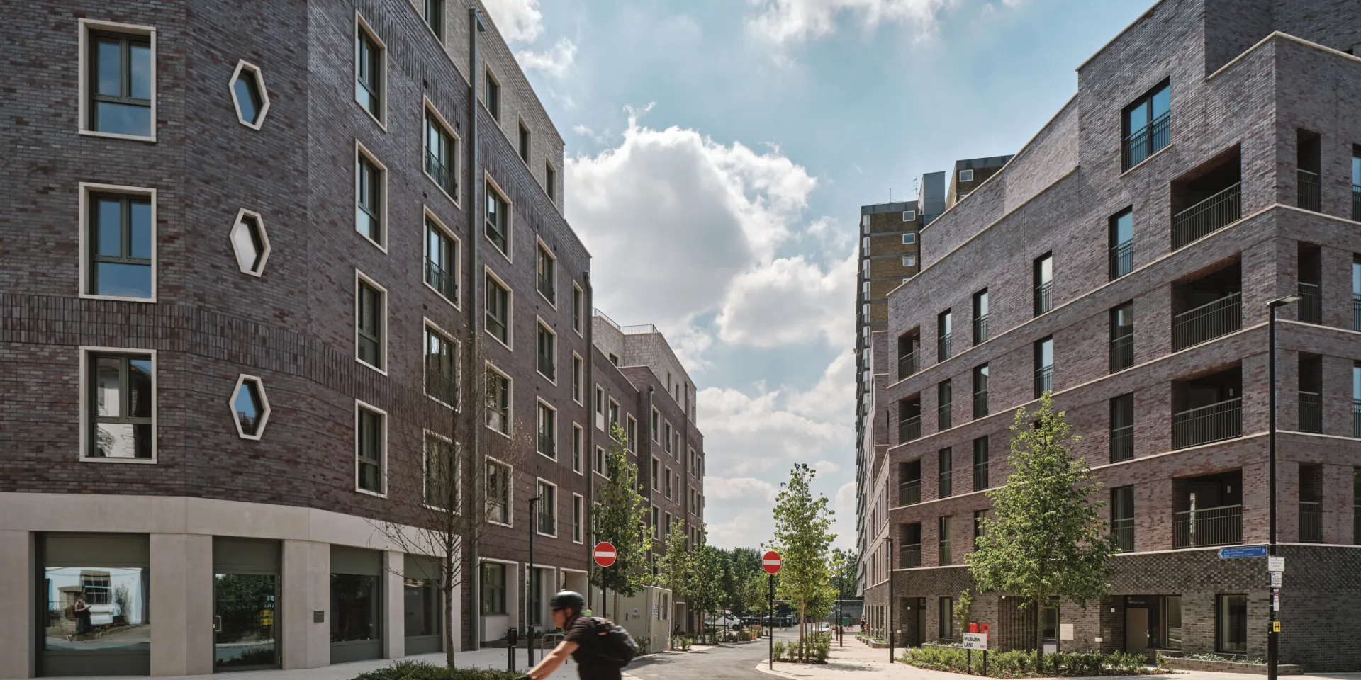 Man bicycling on front of two housing developments