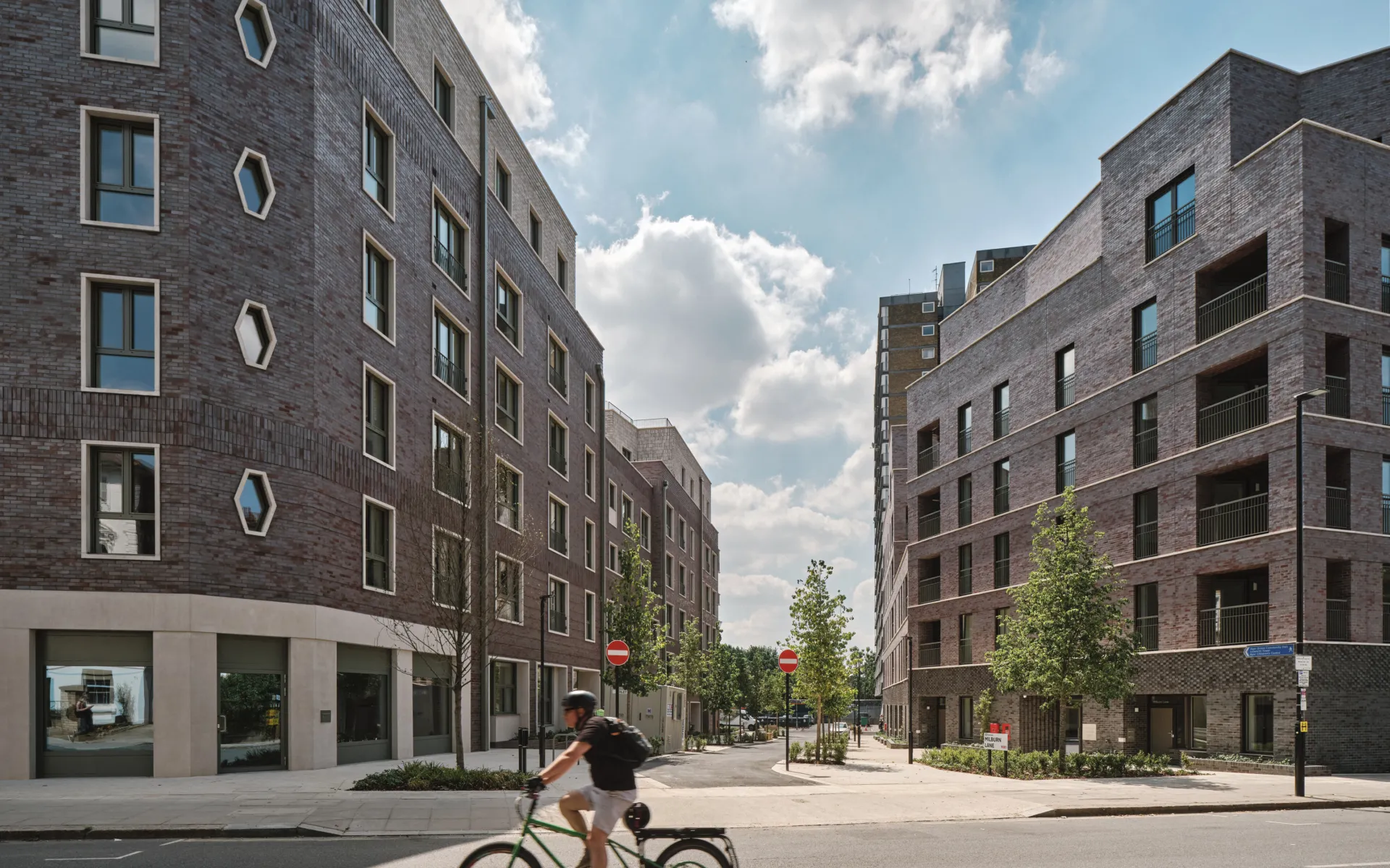 Man bicycling on front of two housing developments