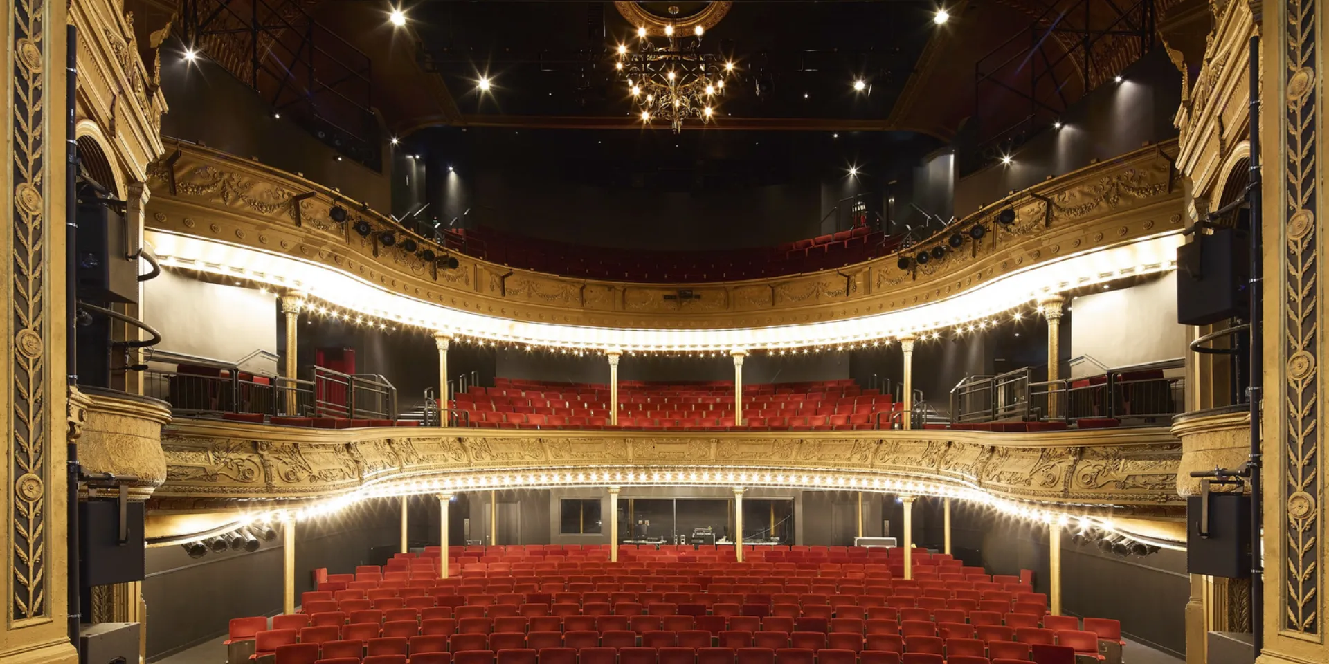 Iimage shows a theatre with red seating and gold painted balconies