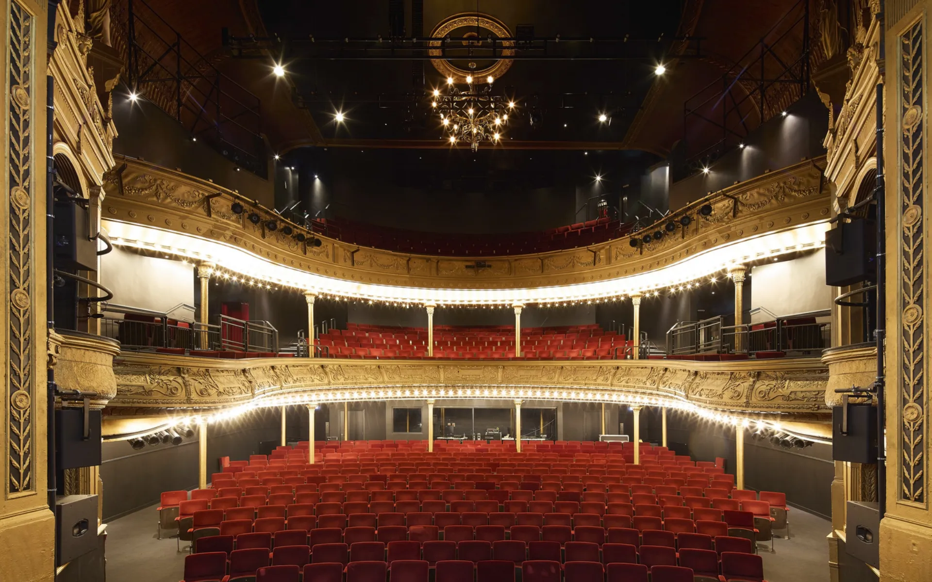 Iimage shows a theatre with red seating and gold painted balconies
