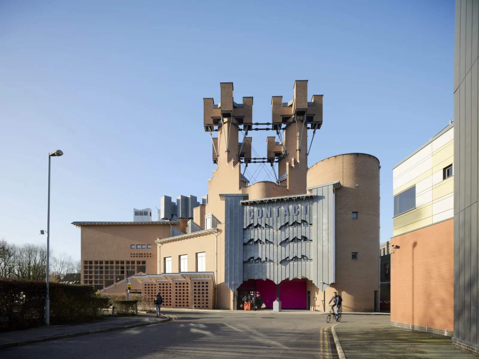 A building with big chimneys and a pink door