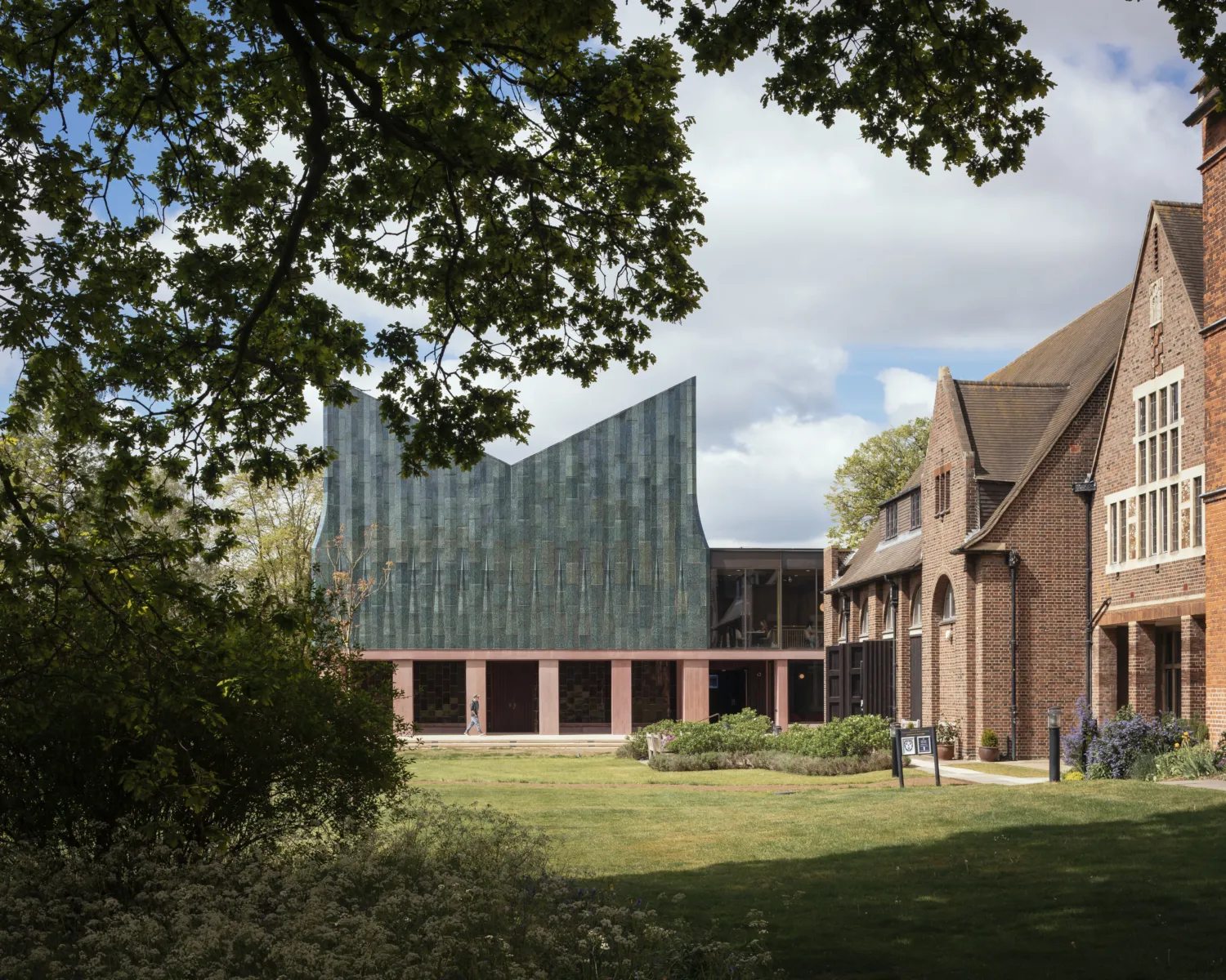 Exterior shot of Homerton College Dining Hall through trees.