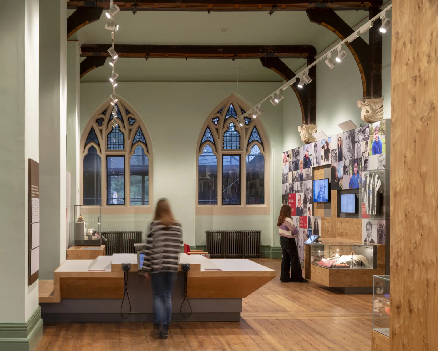 A visitor centre type room with people looking at items in glass cases