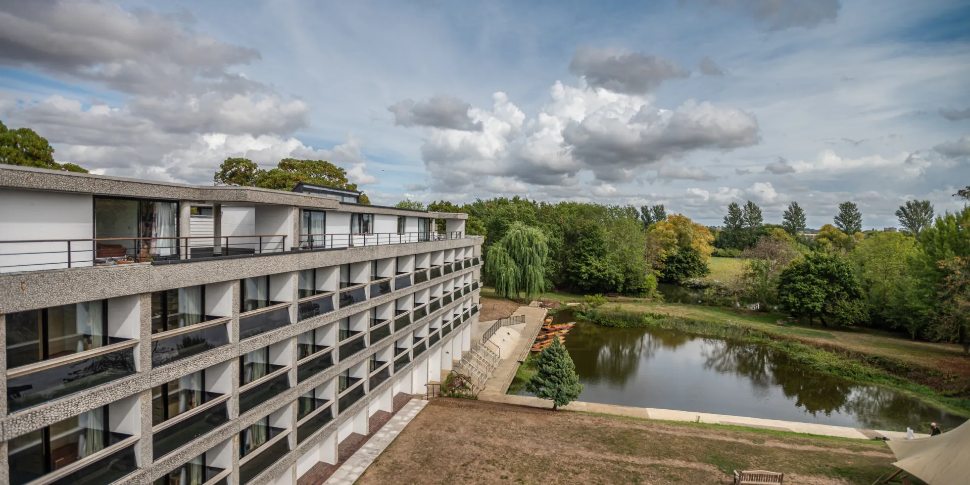 A building against a blue sky in front of a pond